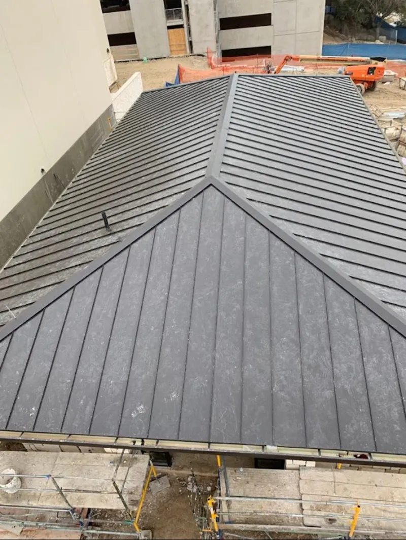 Commercial metal roof construction with crane equipment in Jefferson